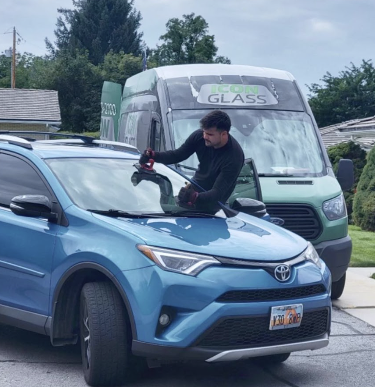 Icon Auto Glass technician replacing a windshield on a customer's driveway in Utah